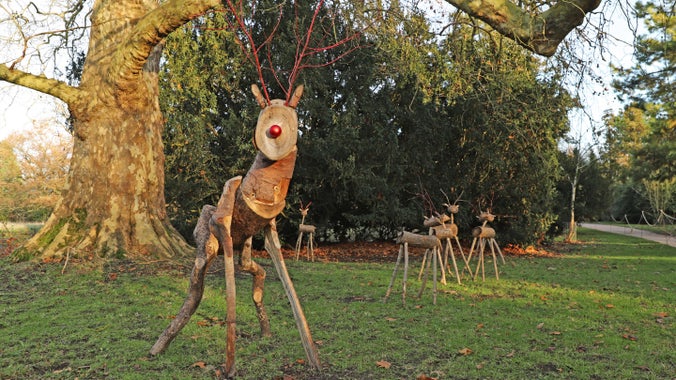 A reindeer made of wood standing tall in nature